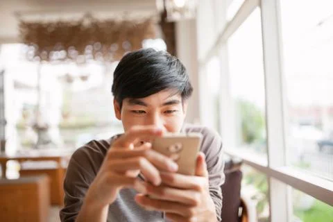Smiling man using smartphone for online chat or shopping Stock Photos