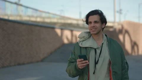 Smiling man using smartphone while walking on street Stock Footage 165287145