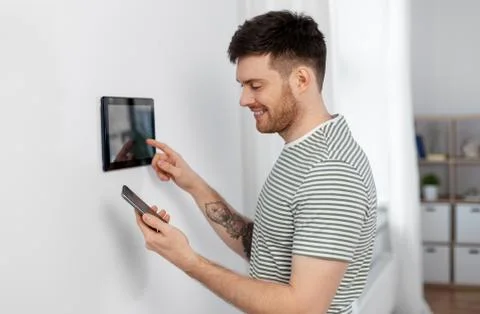 Smiling man using tablet computer at smart home Stock Photos