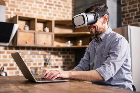 Smiling man using vr glasses at home Stock Photos