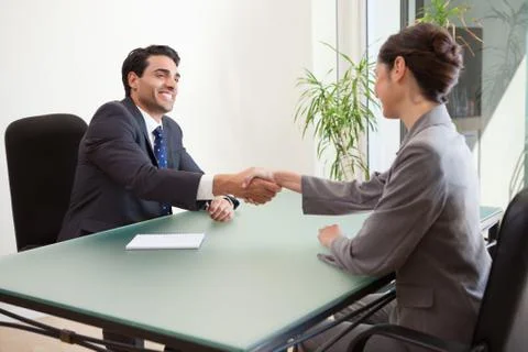 Smiling manager interviewing a good looking applicant Stock Photos