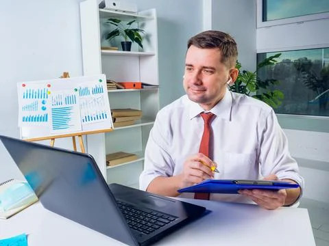Smiling manager makes notes during online communication. New normal concept. Stock Photos