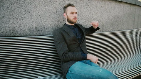 Smiling manager sitting on a bench and phoning Stock Footage 61858675