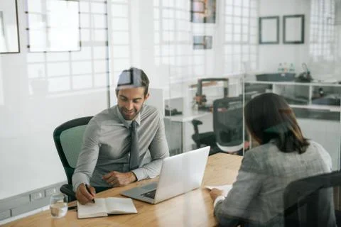 Smiling manager taking notes while conducting an office interview Stock Photos