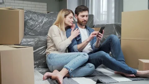 Smiling married couple plan apartment decoration browsing online stores using  Stock Footage 231228467