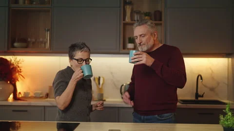 Smiling mature couple drinking tea and communicating, warm family relationships Stock Footage 340920206