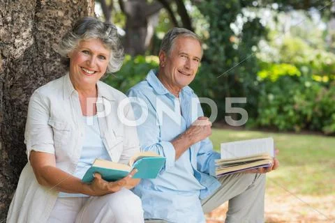 Smiling mature couple reading books together Stock Photos