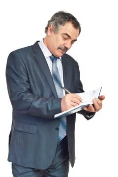 Smiling mature executive taking notes in agenda Foto stock