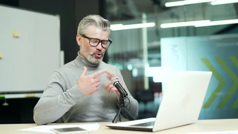 Smiling mature gray haired bearded man is having a video call using a laptop  Stock Footage 232575554