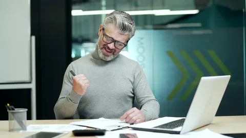 Smiling mature gray haired bearded businessman in glasses making notes in note Stock Footage 232581236