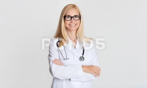 Smiling medical physician doctor posing on grey background Stock Photos