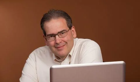 Smiling middle age man at computer Stock Photos