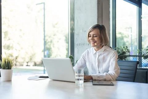 Smiling middle aged female operator call center representative customer suppo Stock Photos