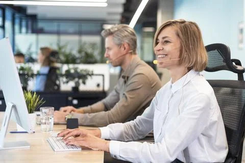 Smiling middle aged female operator call center representative customer suppo Stock Photos