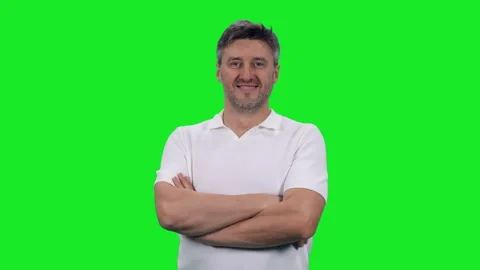 Smiling middle aged man standing with arms crossed on chest against green screen Video stock 298026547