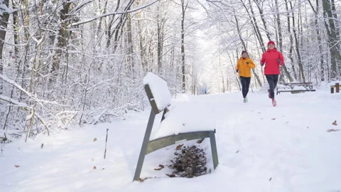 Smiling middle-aged trail running couple man and woman in bright windproof jacke Video stock 315369774