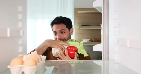 Smiling Middle Eastern Man Retrieves Groceries from the Fridge Stock Footage 254441129