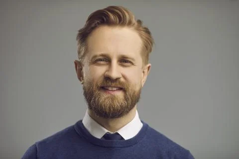 Smiling millennial man looking at camera face portrait on grey copy space Fotos Stock