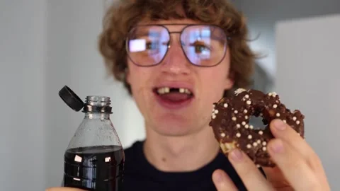Smiling with missing front teeth while holding chocolate donut and soda, illustr Stock Footage 312202098