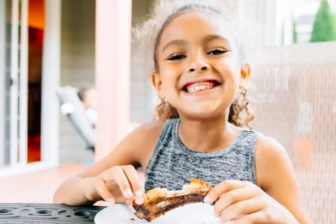 Smiling Mixed Race girl eating rib outdoors Stock Photos