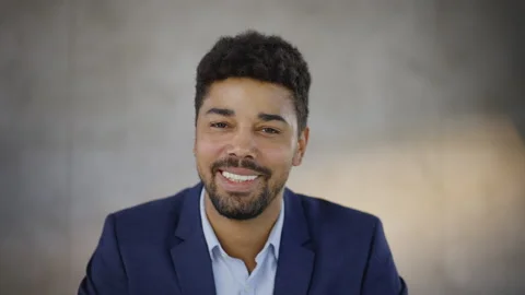 Smiling mixed race man looking at camera and listening. Head and shoulders shot Stock Footage 164463165