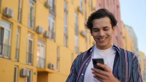 Smiling Mixed Race Man typing Message using Smartphone while Walking. Handsome Stock Footage 156465043