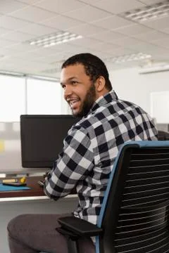 Smiling Mixed Race man using computer in office Foto stock