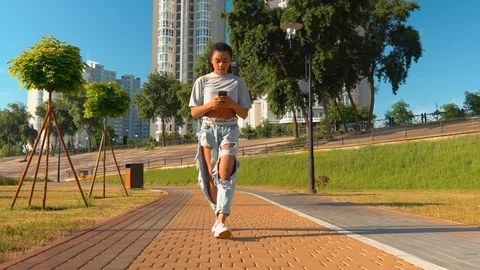 Smiling mixed race millennials stroll outdoors using smartphone cityscape Stock Footage 127845802