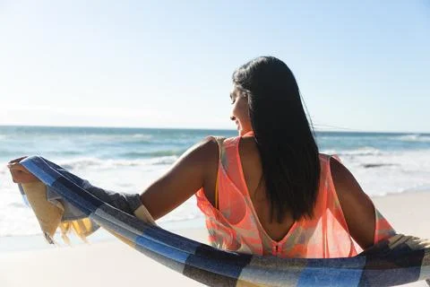 Smiling mixed race woman on beach holiday wearing shawl Stock Photos