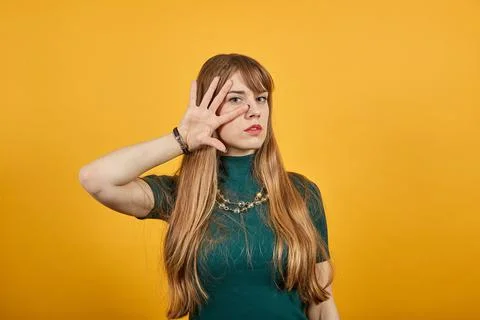 Smiling model brushing hand through hair, fashion posing, with hands in strand. 스톡 사진