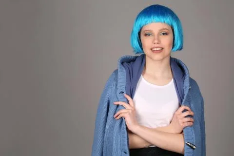 Smiling model coat posing with crossed arms. Close up. Gray background Stock Photos