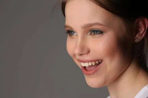 Smiling model with makeup. Close up. Gray background Stock Photos