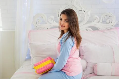 Smiling model sitting on bed Stock Photos
