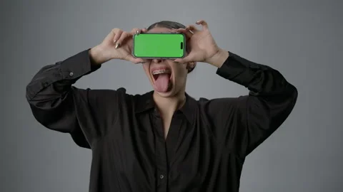 Smiling model with a smartphone on a white background. Advertising on chromakey Stock Footage 267821445