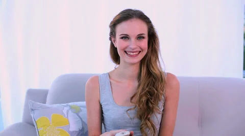 Smiling model watching tv on the couch Stock Footage 29393496