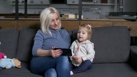 Smiling mom with child watching educational program Video stock 104652750