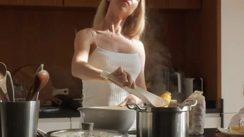Smiling Mom Cooking Corn on the Cob, Takes it From Boiling Water with Tongs Stock Footage 309007329