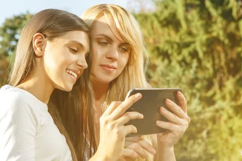Smiling mom using tablet with pretty daughter Stock Photos