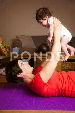 Smiling Mother Exercising With Her Baby