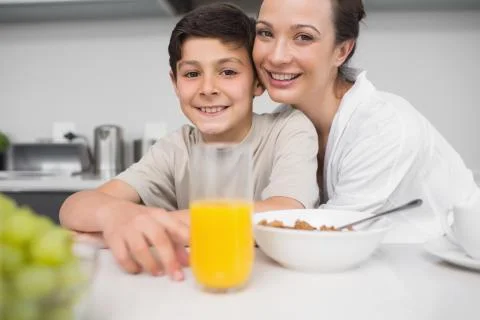 Smiling mother with son at breakfast table in kitchen Foto stock