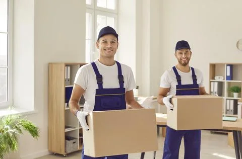 Smiling Movers with Cardboard Boxes during Relocation Stock Photos