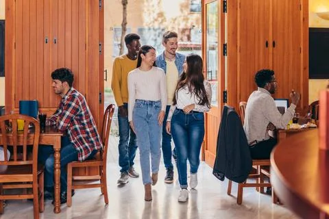 Smiling multiethnic group entering a bar Stock Photos