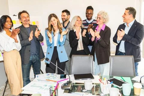 Smiling multiracial colleagues clapping hands in meeting at office Stock Photos