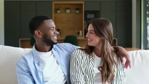 Smiling Multiracial Couple Sharing a Happy Moment on the Couch, Enjoying Time To 스톡 동영상 333539145