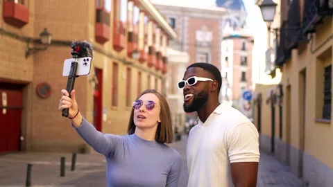 Smiling multiracial couple vlogging through mobile phone in street Stock Footage 291516436