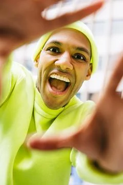 Smiling multiracial man framing the camera with hands in city Foto stock