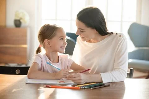 Smiling nanny developing drawing skills of little child girl. Foto stock