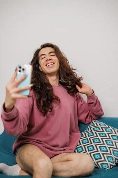 Smiling non-binary person having fun while taking a selfie with a mobile phon Stock Photos