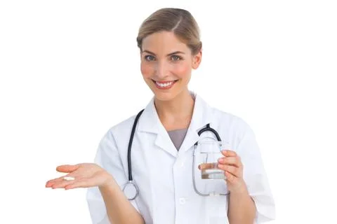 Smiling nurse holding drugs and water glass Stock Photos