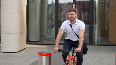 Smiling office worker leaving work riding bicycle outdoors Stock Footage 157380324